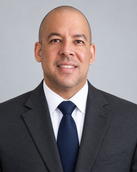 Erick Martinez, CPA, wearing a dark suit and navy tie